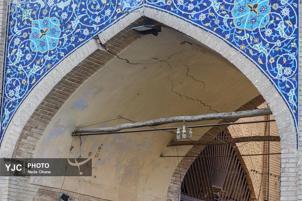 نمای نزدیک از شکاف‌های ناشی از فرونشست زمین در بناهای تاریخی و خیابان‌های اصفهان که نشان‌دهنده آسیب به زیرساخت‌ها و میراث فرهنگی است.