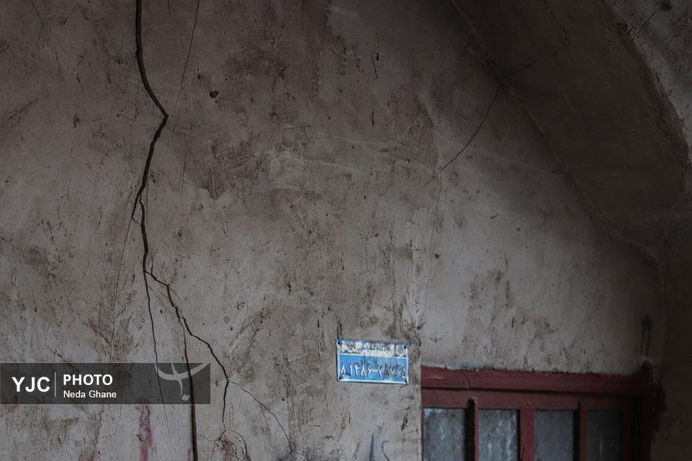 نمای نزدیک از شکاف‌های ناشی از فرونشست زمین در بناهای تاریخی و خیابان‌های اصفهان که نشان‌دهنده آسیب به زیرساخت‌ها و میراث فرهنگی است.