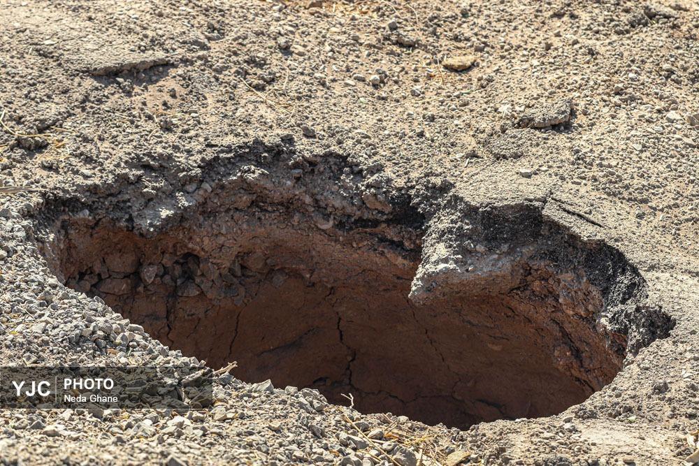 نمای نزدیک از شکاف‌های ناشی از فرونشست زمین در بناهای تاریخی و خیابان‌های اصفهان که نشان‌دهنده آسیب به زیرساخت‌ها و میراث فرهنگی است.