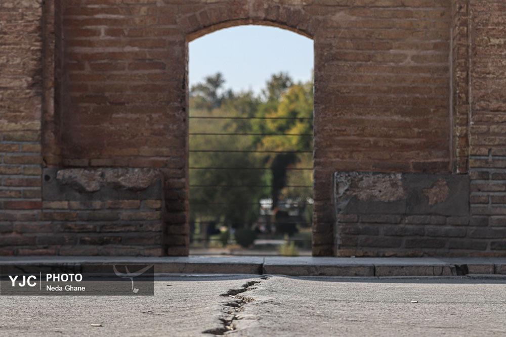 نمای نزدیک از شکاف‌های ناشی از فرونشست زمین در بناهای تاریخی و خیابان‌های اصفهان که نشان‌دهنده آسیب به زیرساخت‌ها و میراث فرهنگی است.