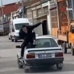 ببینید | حرکت جنون‌آمیز مرد جوان وسط خیابان؛ نشستن روی سقف خودرو!