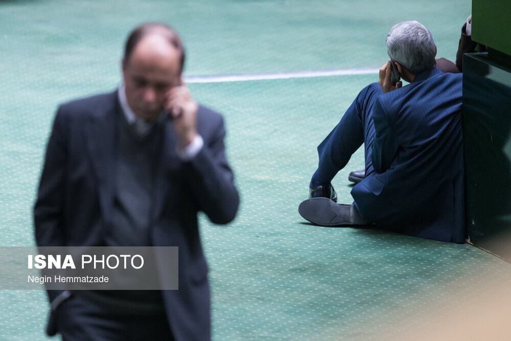 عکس | قابی عجیب در صحن علنی مجلس؛ تلفن حرف زدن روی زمین و تکیه به جایگاه!