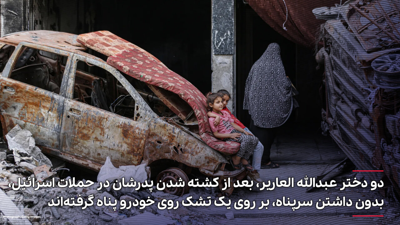 عکس | قابی تلخ از غزه؛ پناه گرفتن دو دختر روی خودروی منهدم شده
